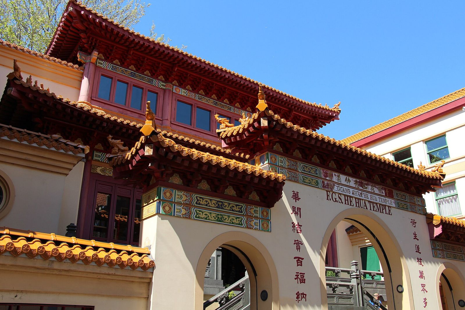 The red-and-gold roofs and arched gateway of the Fo Guang Shan He Hua Buddhist temple on the Zeedijk against a blue sky