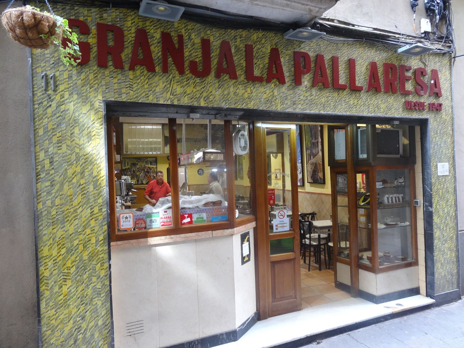 The shopfront of Granja La Pallaresa on Carrer de Petritxol: red letters reading Granja La Pallaresa, desde 1947, over a tiled front and an open door into a small café