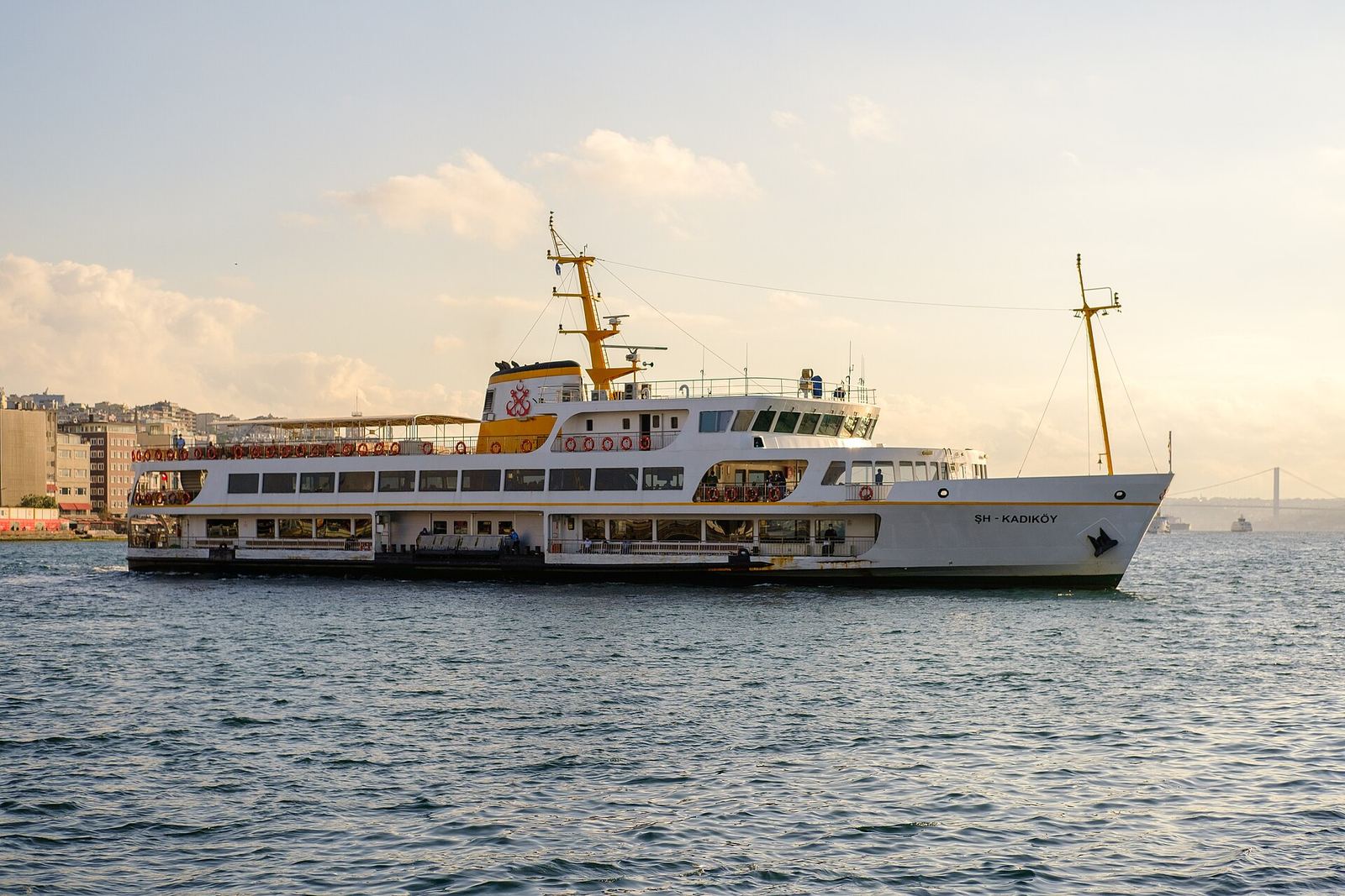 A white City Lines ferry on the Kadıköy route crossing the water in soft evening light