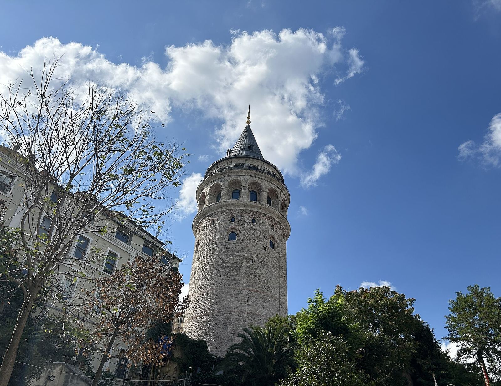 The round stone Galata Tower and its conical cap against a blue sky
