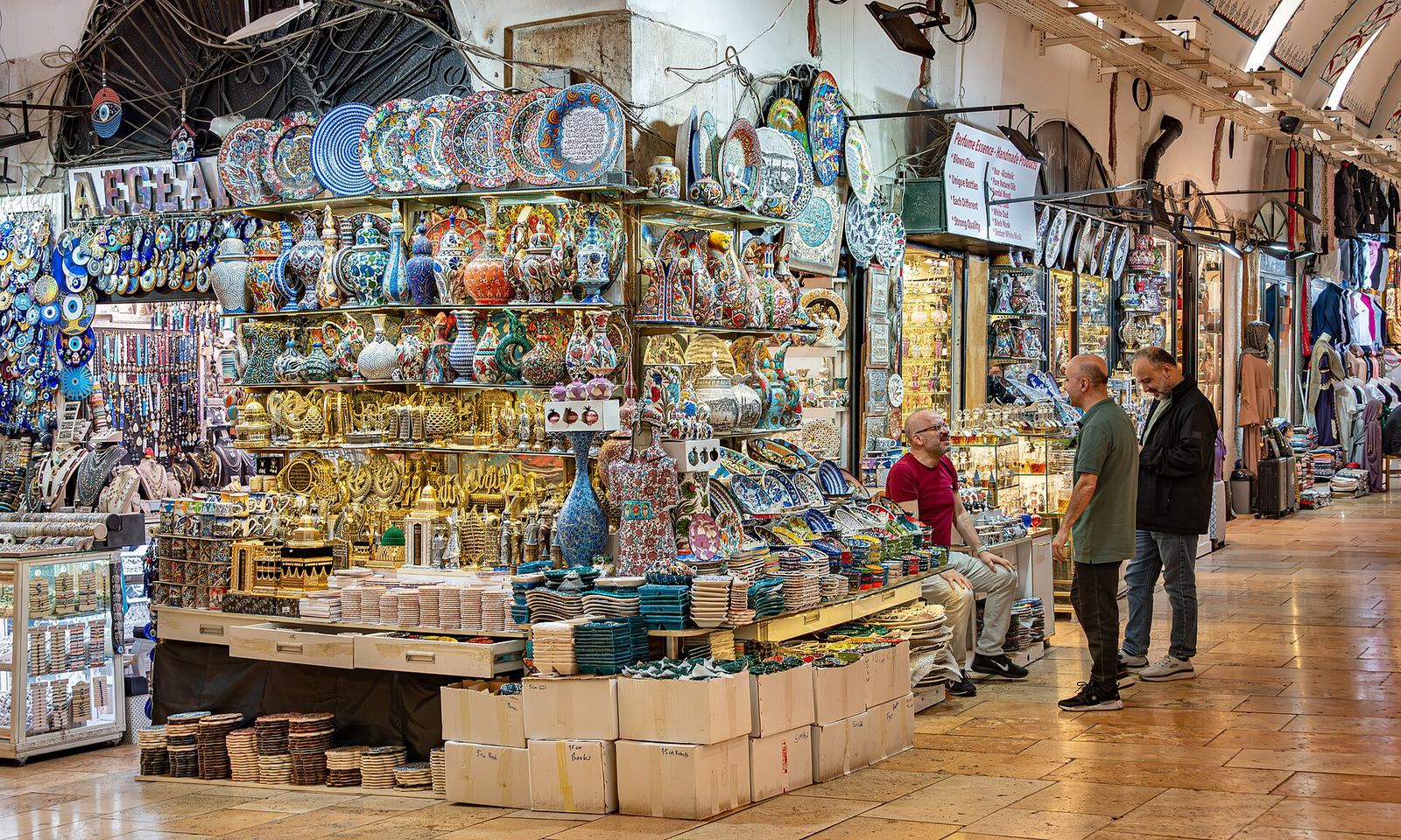 A Grand Bazaar stall stacked with painted ceramic plates and bowls under a vaulted ceiling