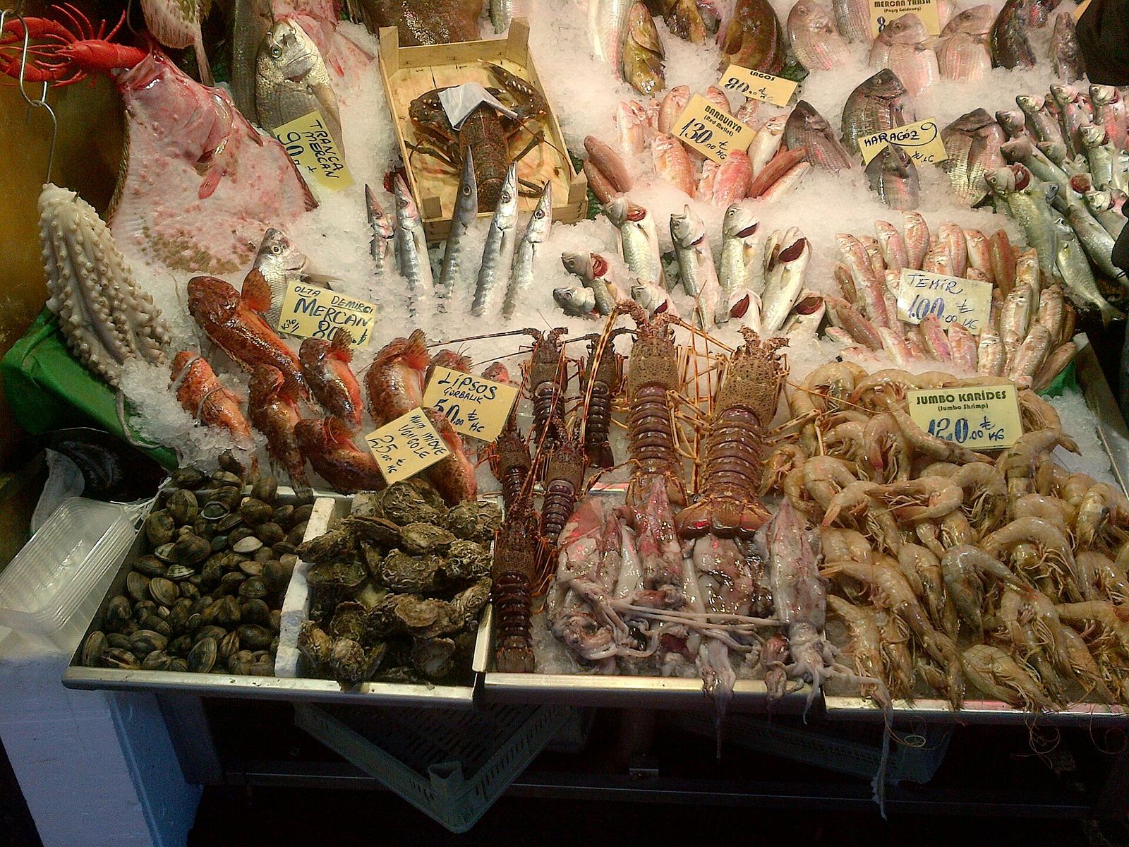 Fish, lobsters, prawns and mussels laid out on ice at a Kadıköy market stall