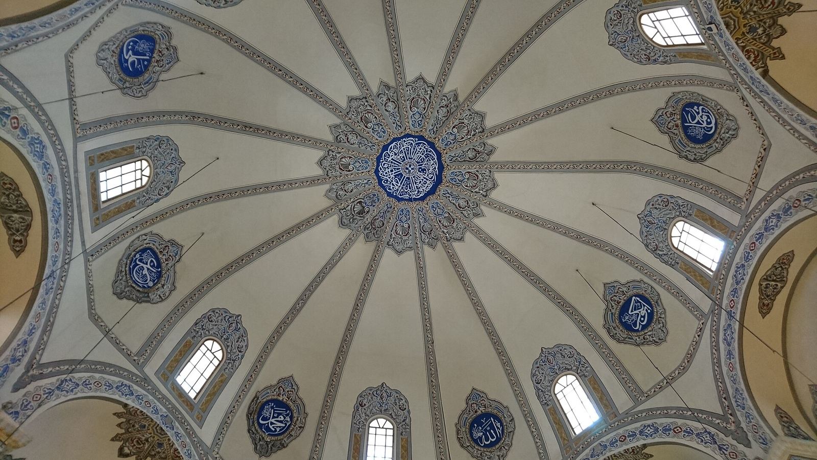 Looking up into Little Hagia Sophia's ribbed white dome, ringed by arched windows and blue calligraphy medallions