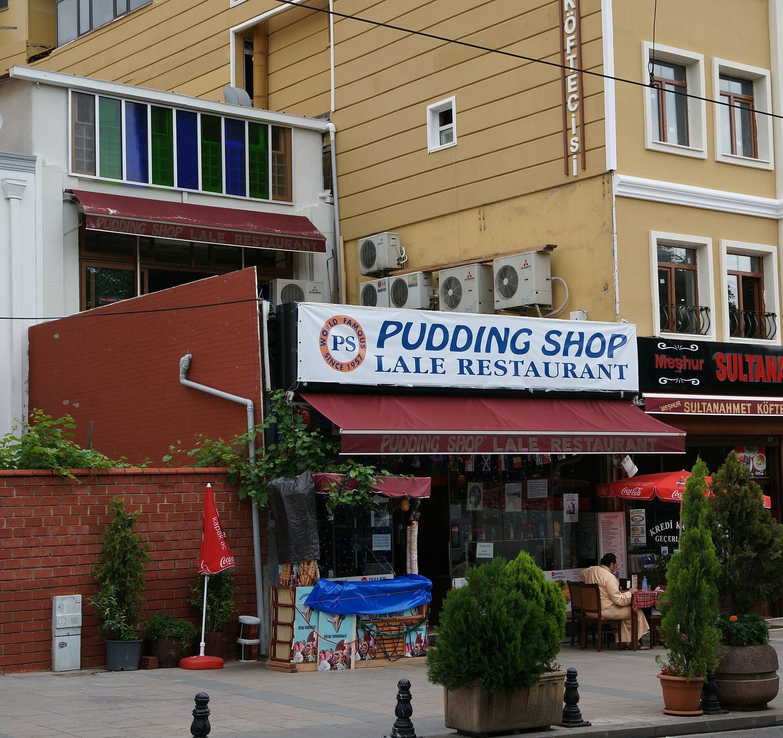 The Pudding Shop on Divanyolu, its red awning under a sign reading 'Pudding Shop Lale Restaurant'