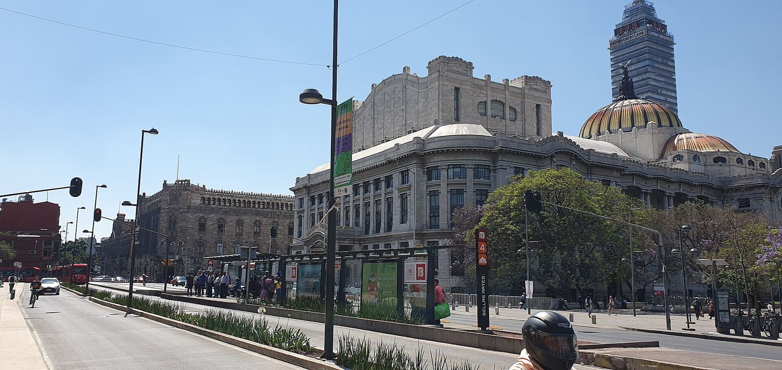 The Palacio de Bellas Artes with its golden domes beside the Palacio Postal on Eje Central, with the Torre Latinoamericana rising behind on a sunny day