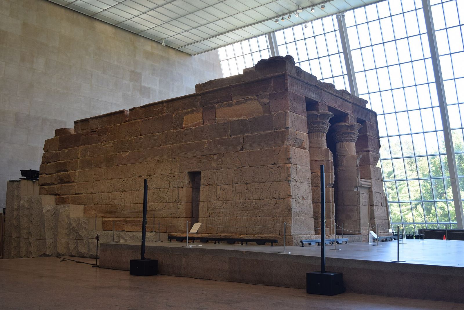 The sandstone Temple of Dendur inside the Met's Sackler Wing, with a tall slanted glass wall on the right letting in daylight from Central Park