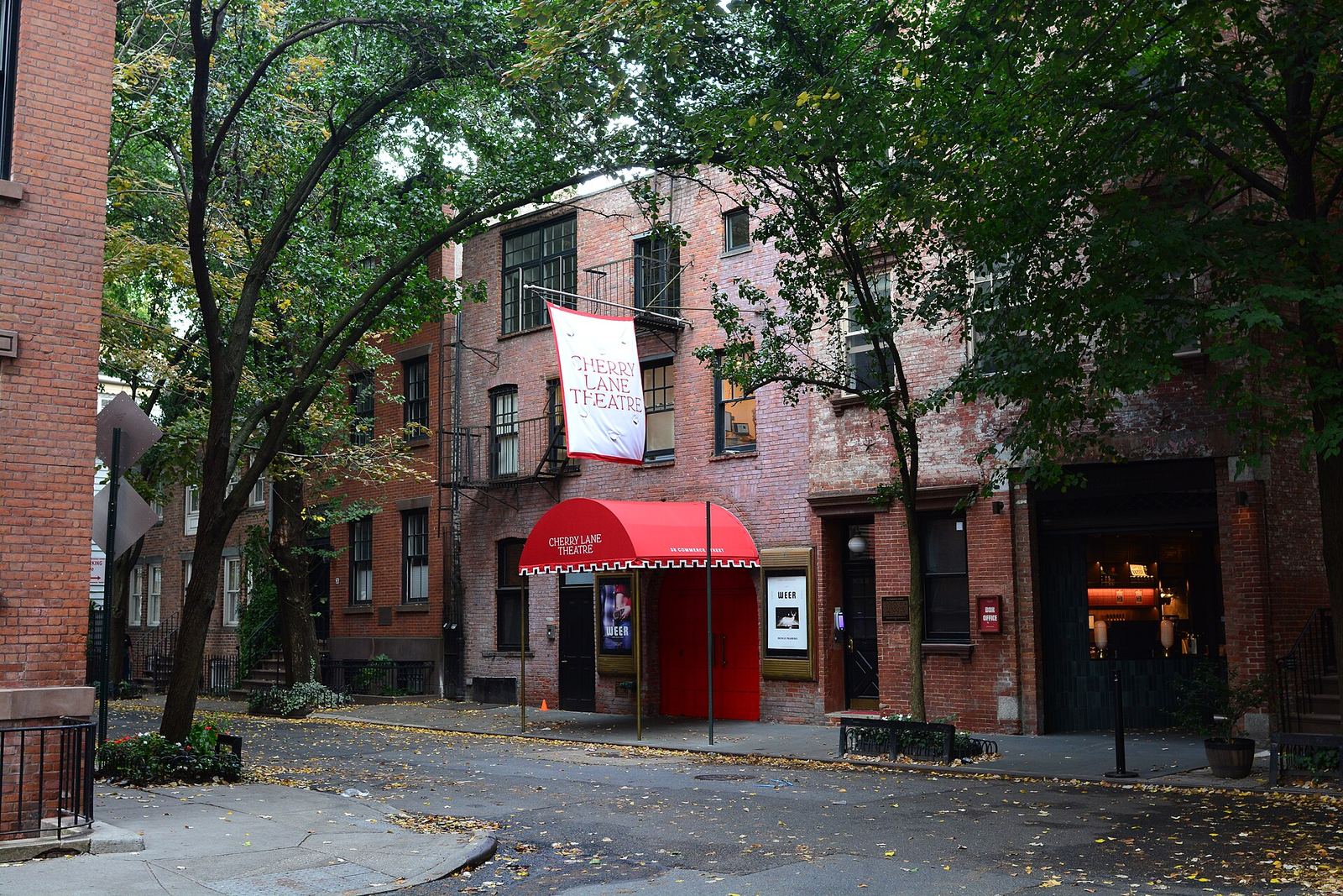 Commerce Street in the West Village: old brick rowhouses under leafy trees and the Cherry Lane Theatre's red awning where the quiet street bends