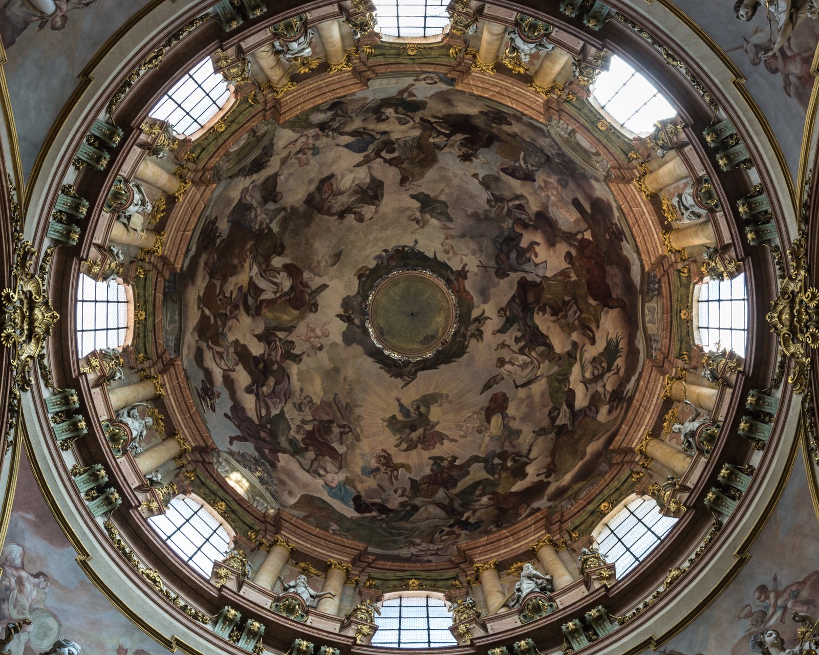 Looking straight up into the dome of St Nicholas Church: a painted Baroque fresco ringed by windows and gilded stucco