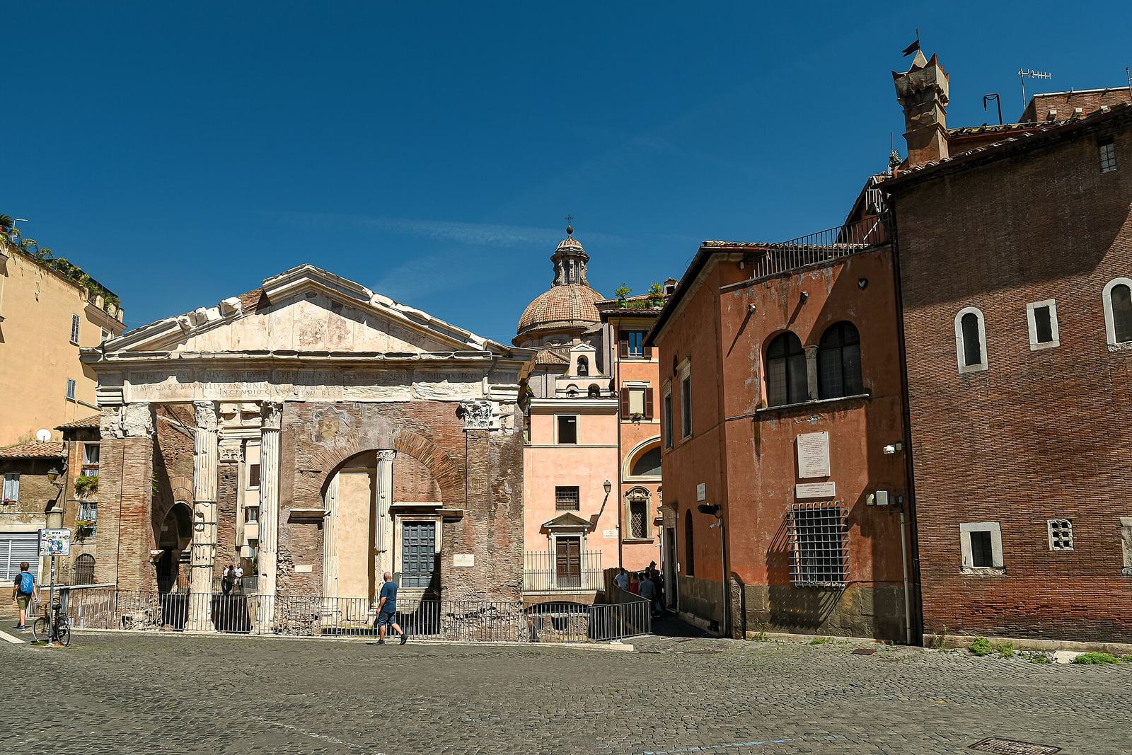 The Portico d'Ottavia in the Jewish Ghetto, a ruined Roman portico with a brick arch beside red-brick houses, a few minutes' walk from Sora Margherita