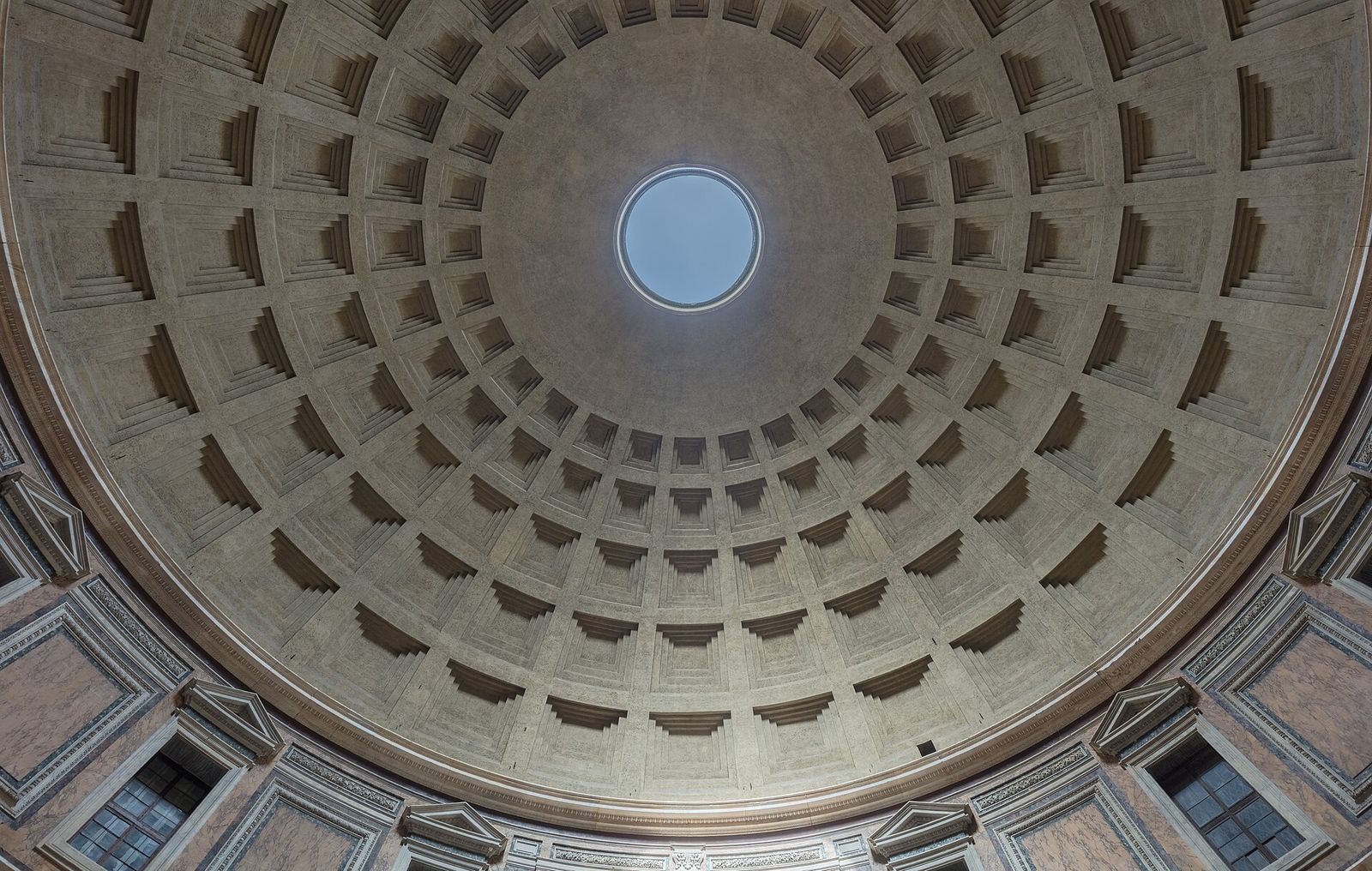 Looking up at the Pantheon's coffered concrete dome, with blue sky showing through the round oculus at the top