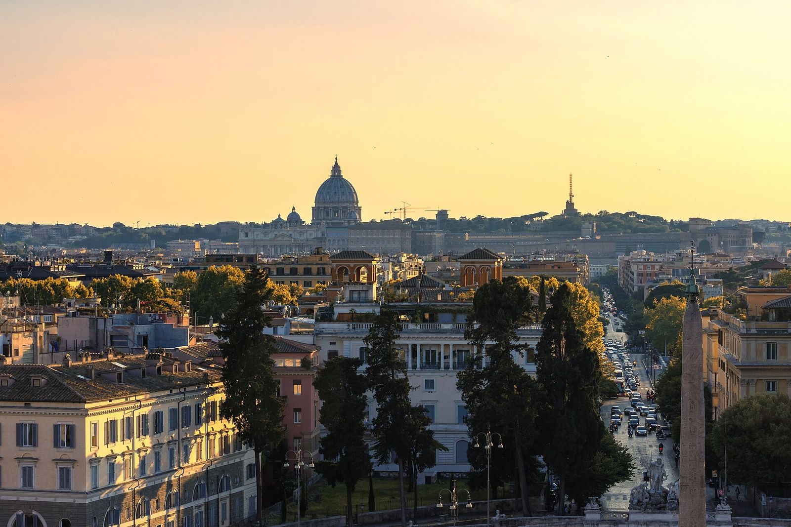 Sunset from the Pincio terrace: a golden sky over Rome's rooftops with St Peter's dome on the horizon and the obelisk of Piazza del Popolo on the right