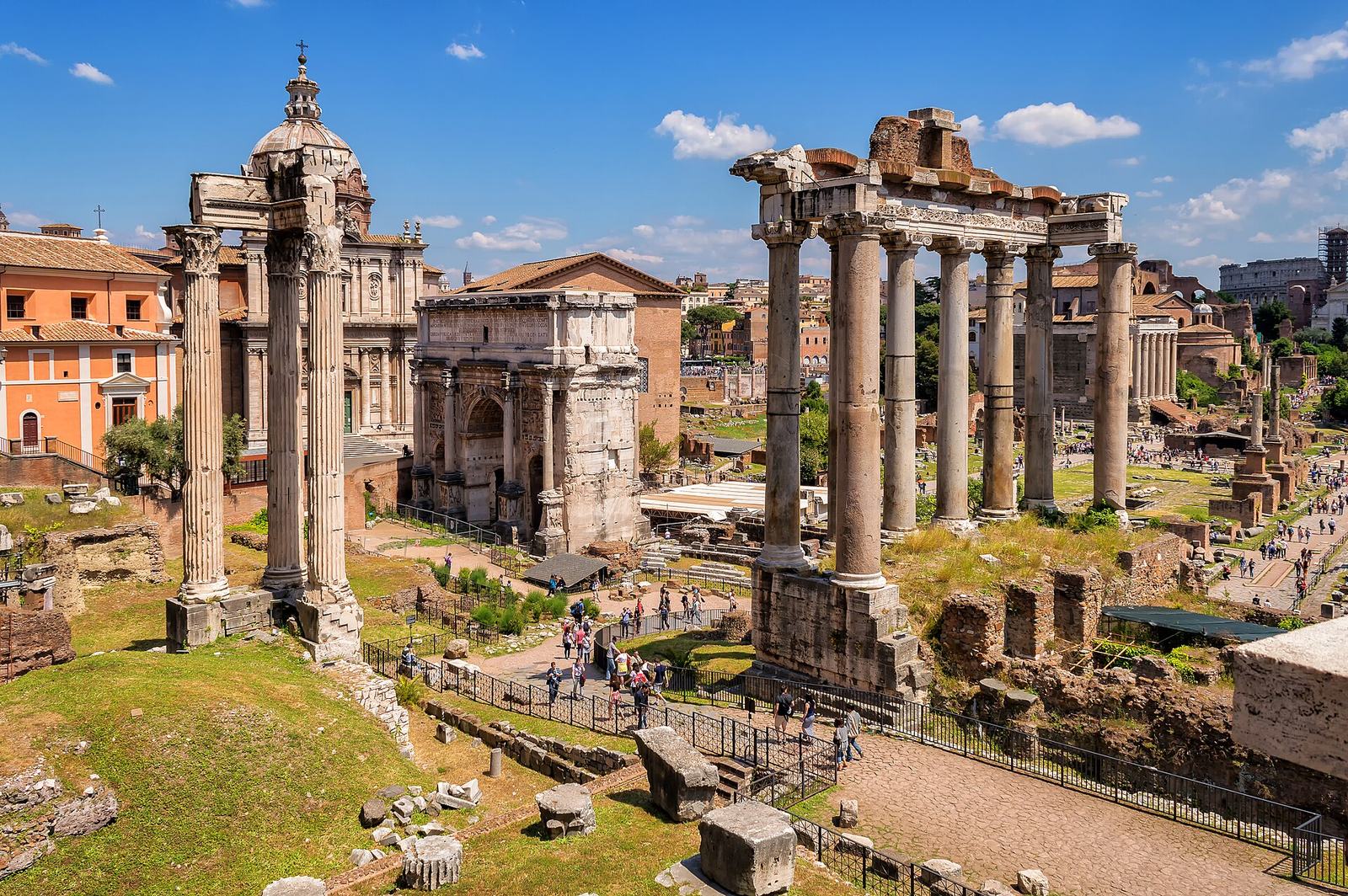 The Roman Forum from the Capitoline Hill on a sunny day: the columns of the Temple of Saturn on the right, the Arch of Septimius Severus in the middle and three columns of the Temple of Vespasian on the left