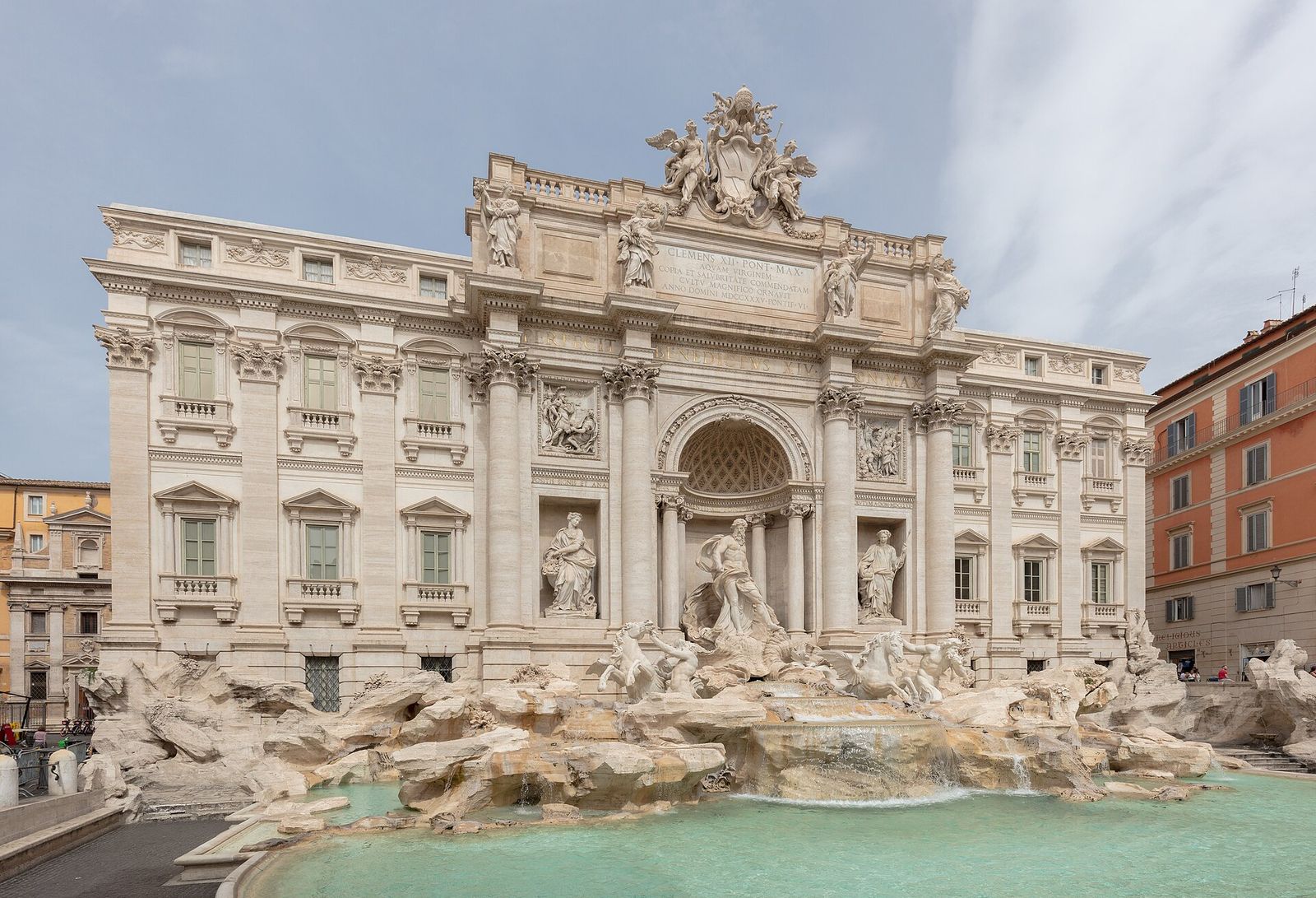 The Trevi Fountain with nobody on its steps: the white palace front with Oceanus in the central niche and turquoise water in the basin, under a grey sky