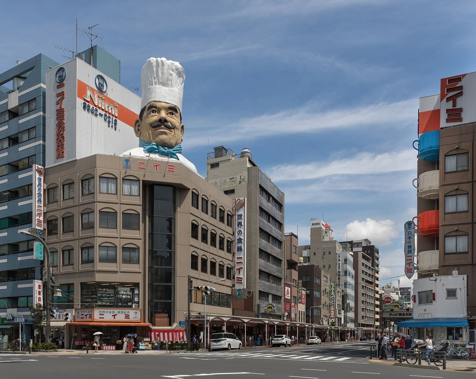 The giant chef's head on the roof of the Niimi tableware building at the southern end of Kappabashi-dori, under a blue sky
